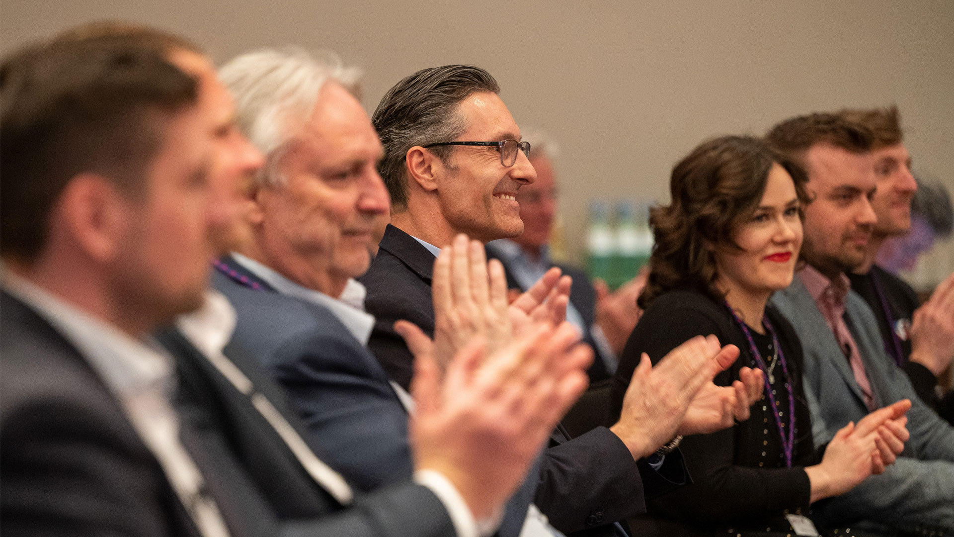 Klatschende Konferenzteilnehmer sitzend im Plenum 