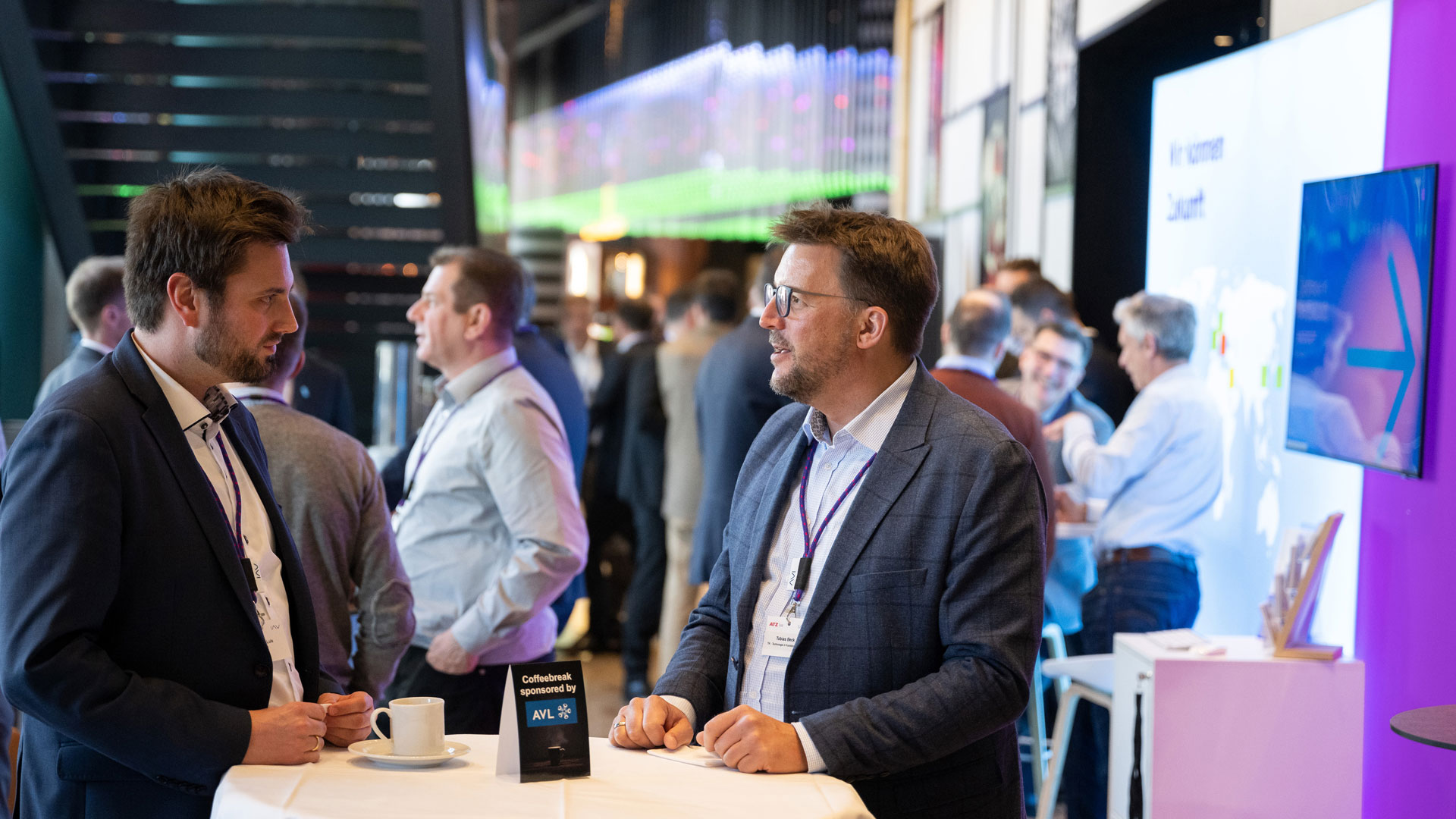 Two gentlemen in conversation at an exhibition stand.