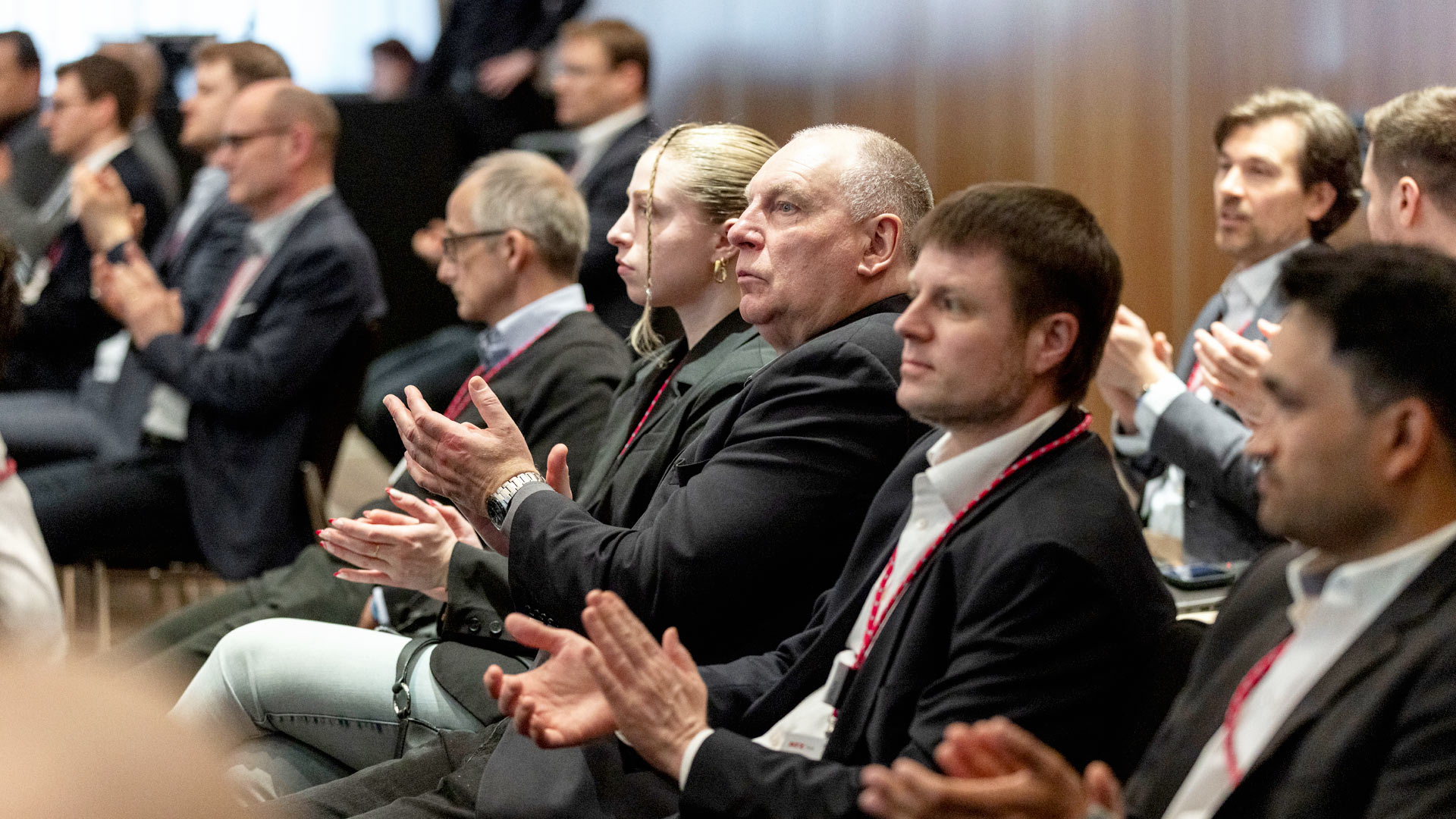 Clapping conference participants sitting in the plenum