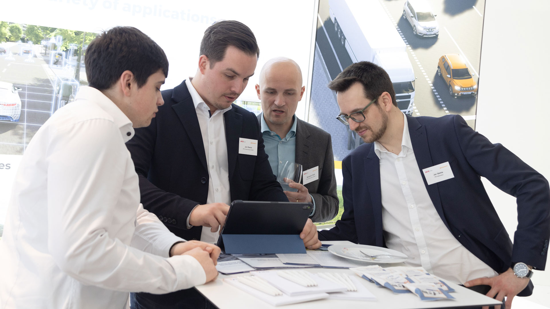 Four gentlemen in conversation at an exhibition stand.