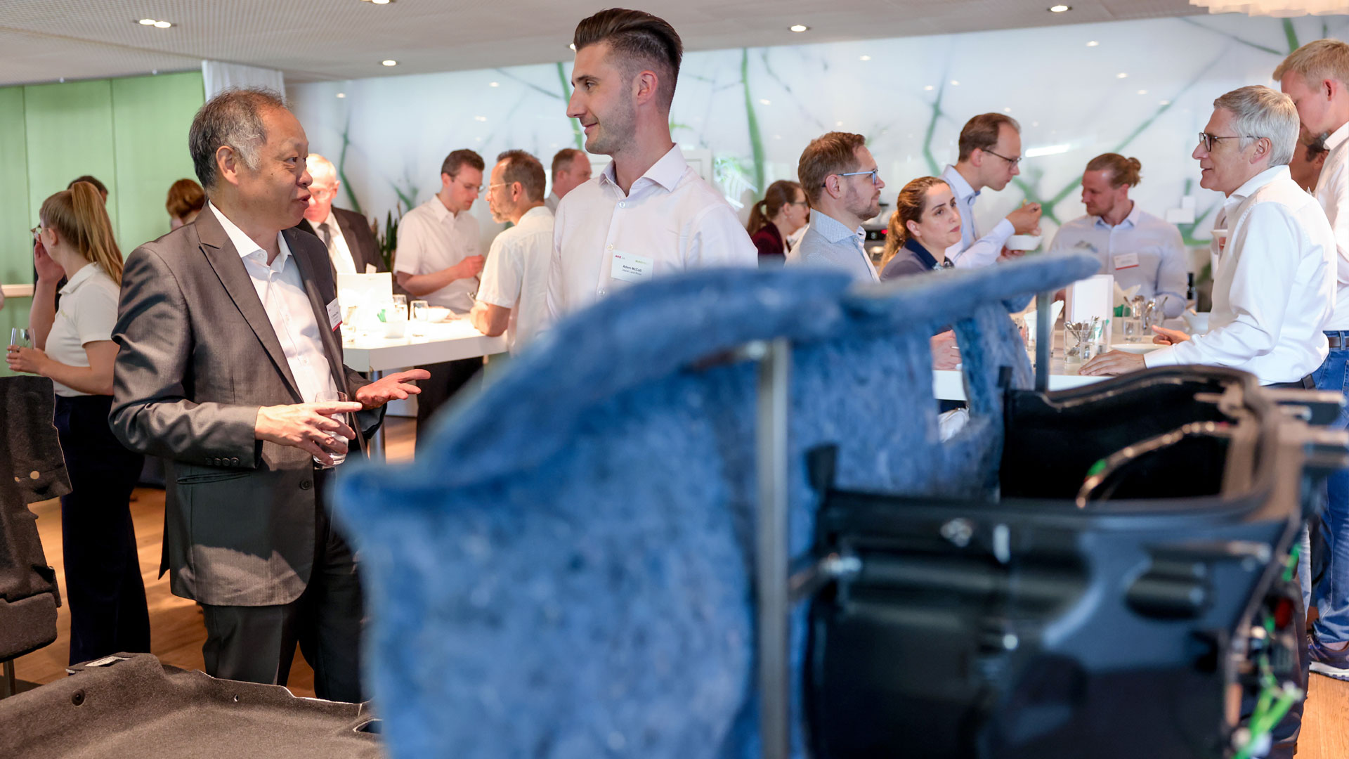 Gruppen von Konferenzteilnehmern unterhalten sich im Ausstellungsbereich.