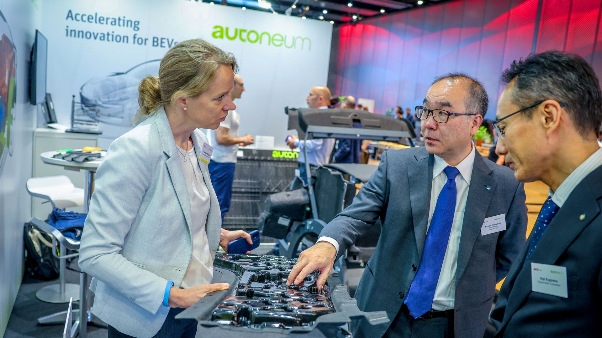 Zwei Herren und eine Dame im Gespräch am Ausstellungsstand von Autoneum.