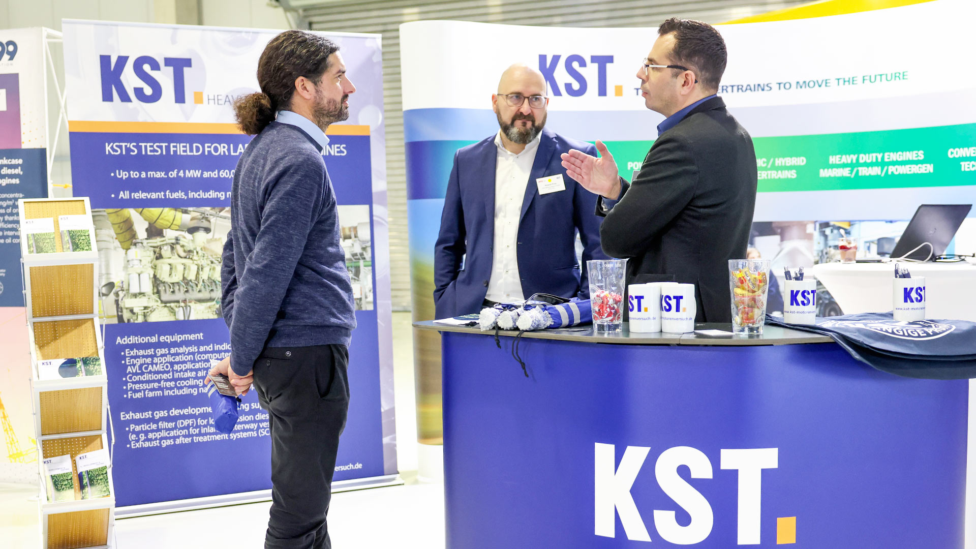Three gentlemen in conversation at the KST exhibition stand.
