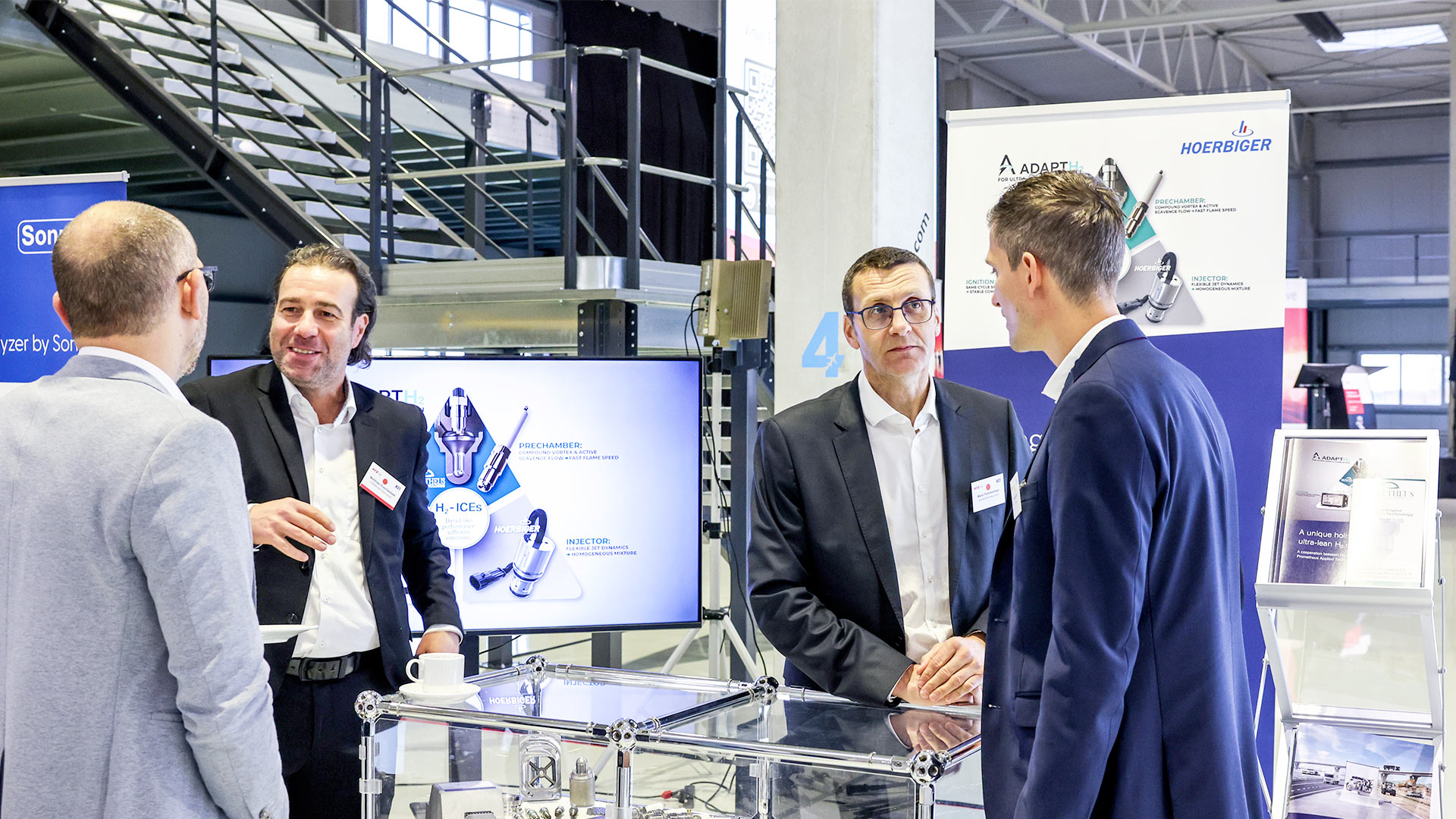Four gentlemen in conversation at the Hoerbiger exhibition stand.