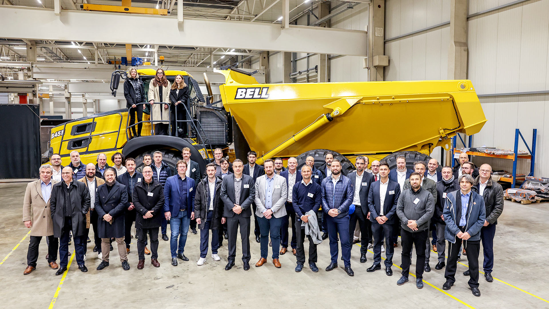 Werksführung bei BELL. Gruppenfoto vor einem großen gelben Muldenkipper.