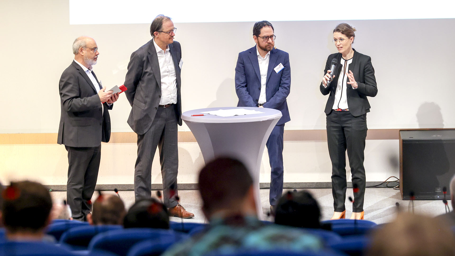 Four speakers in a panel discussion on stage