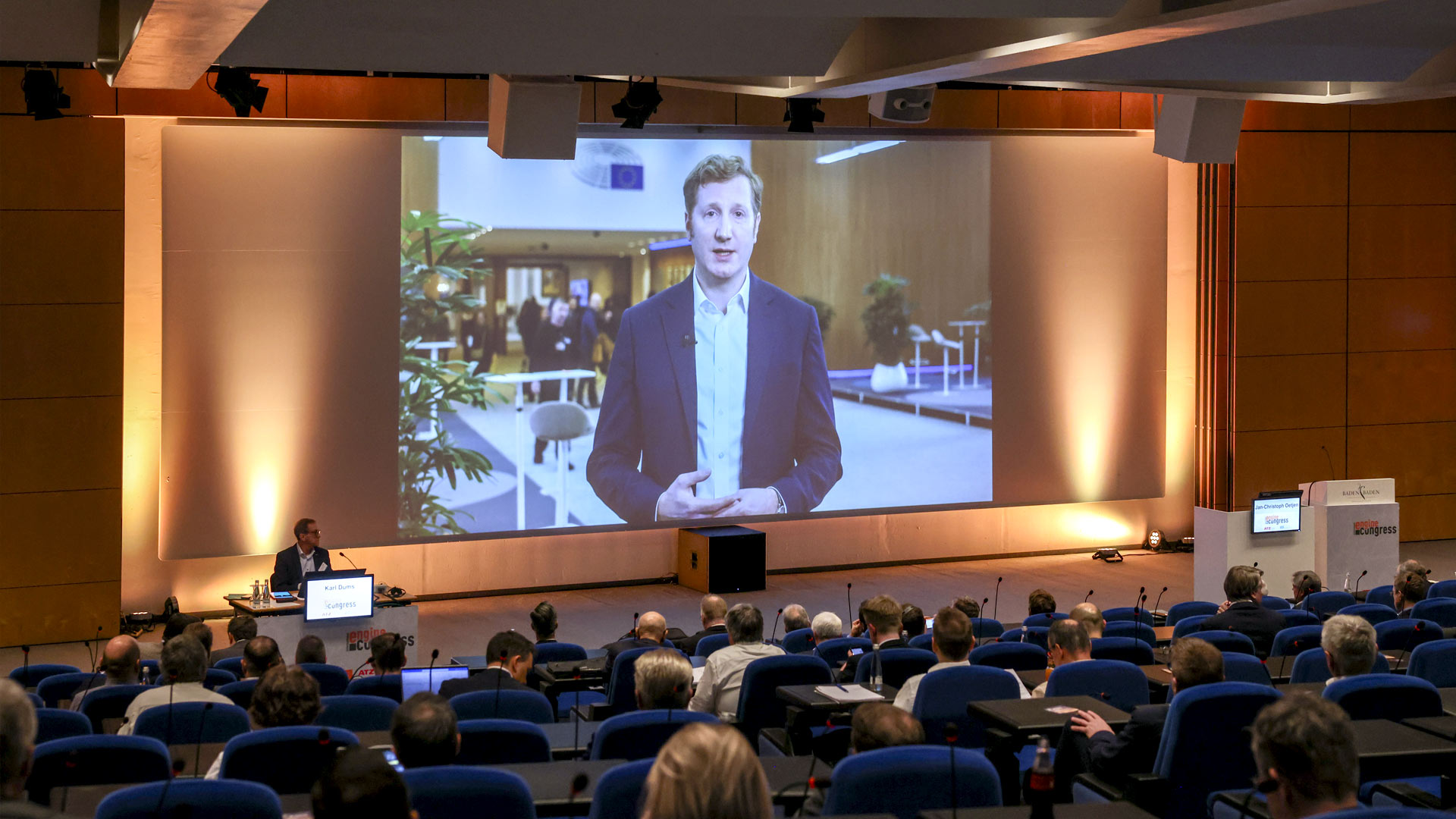 Video presentation speaker on stage screen in front of the plenum