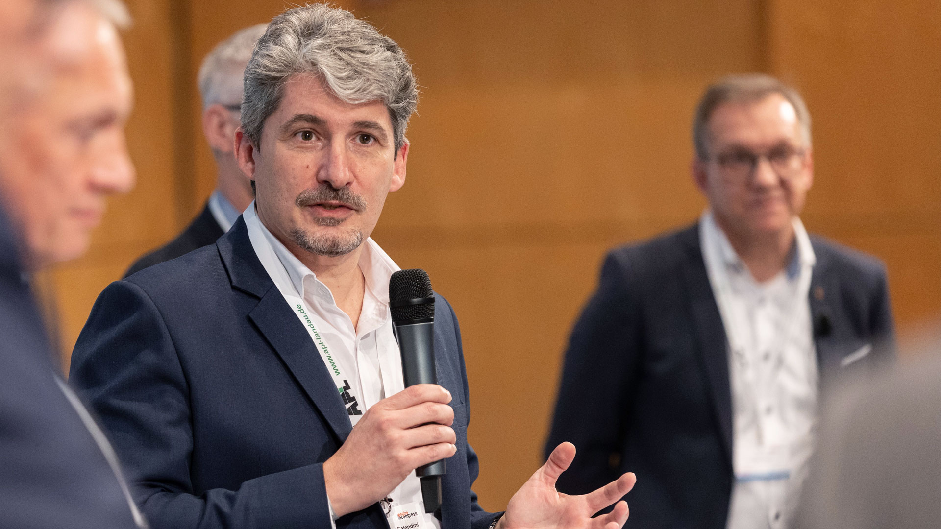 Podiumsdiskussion mit mehreren Konferenzbeteiligten. 
