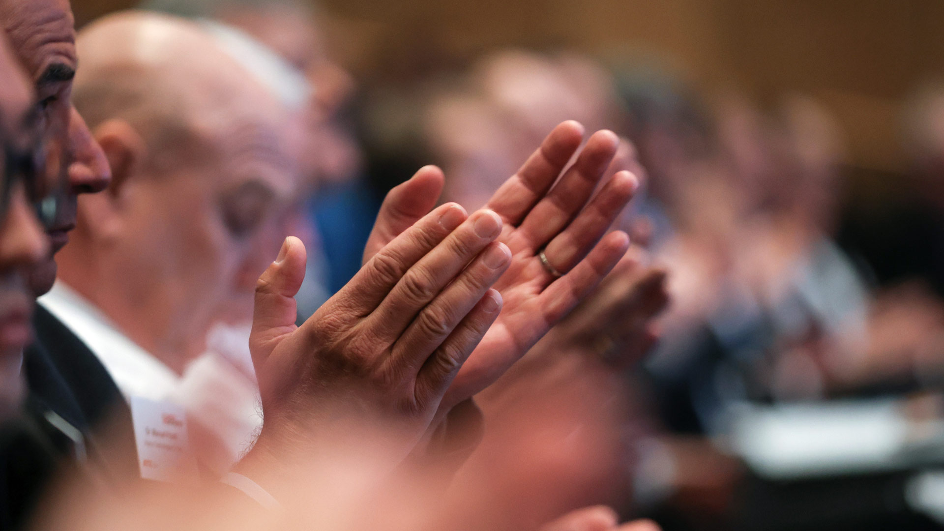 Klatschende Konferenzteilnehmer sitzend im Plenum 