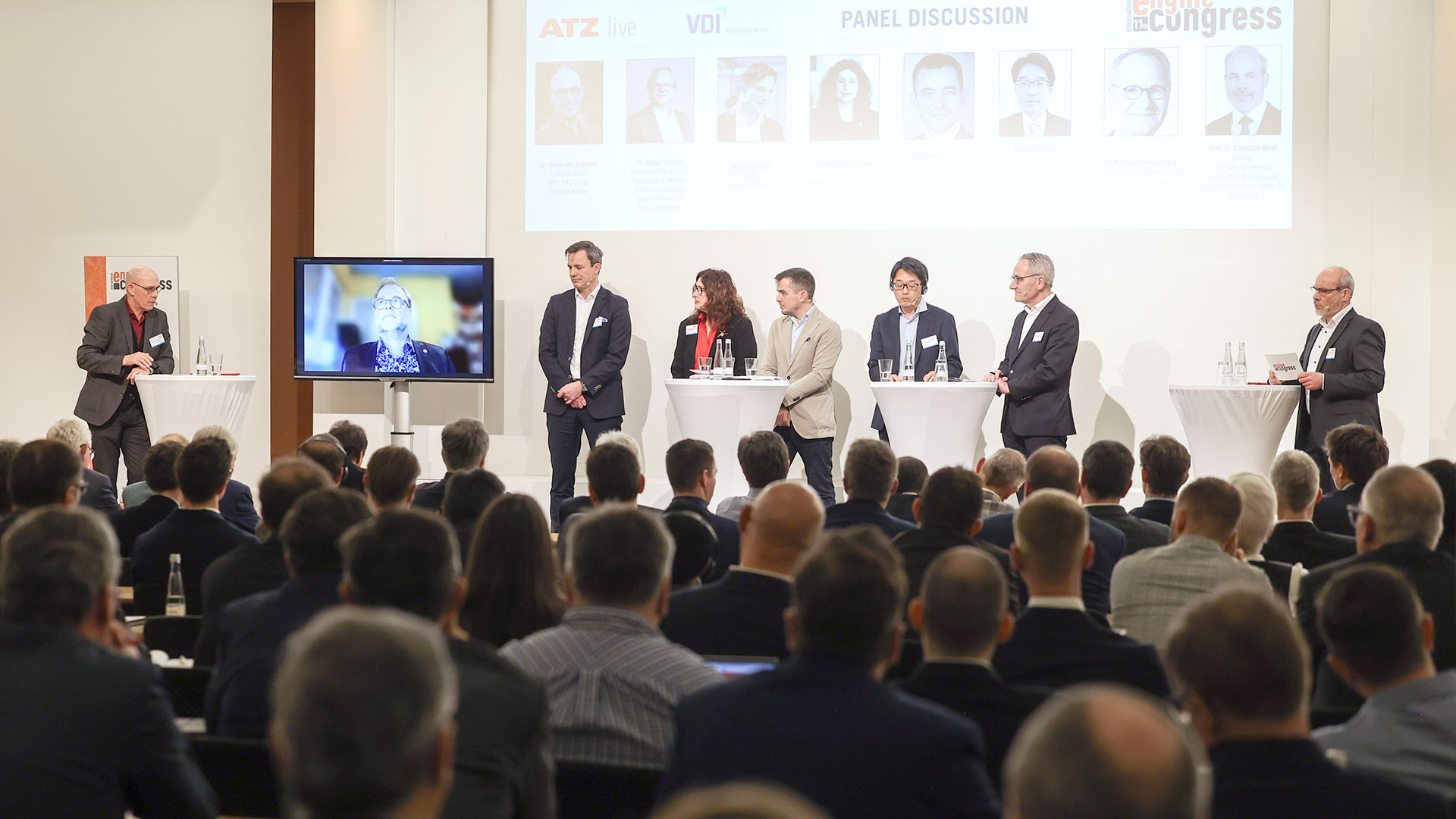 Podiumsdiskussion mit mehreren Konferenzbeteiligten. Im Vordergrund das Publikum