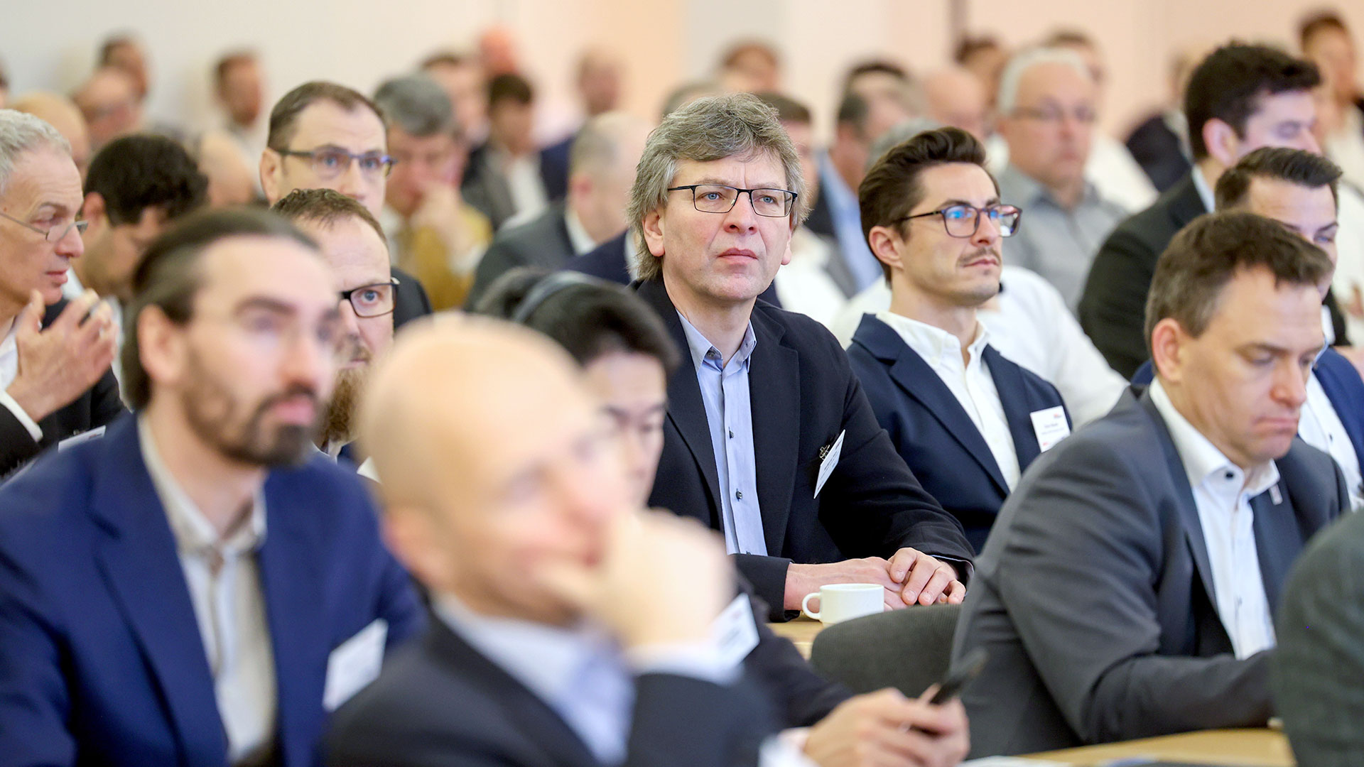 Konferenzteilnehmer sitzend im Plenum 