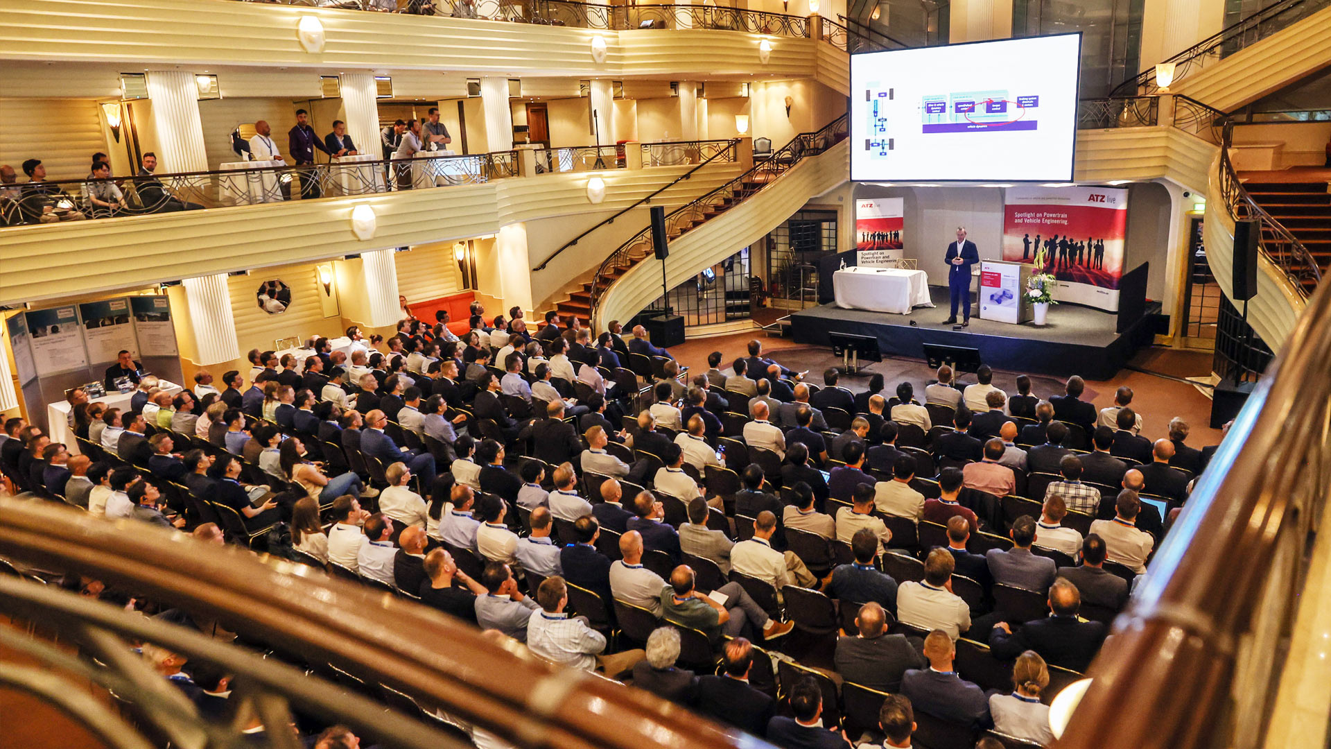 Referent auf der Bühne vor vollem Konferenzsaal. 