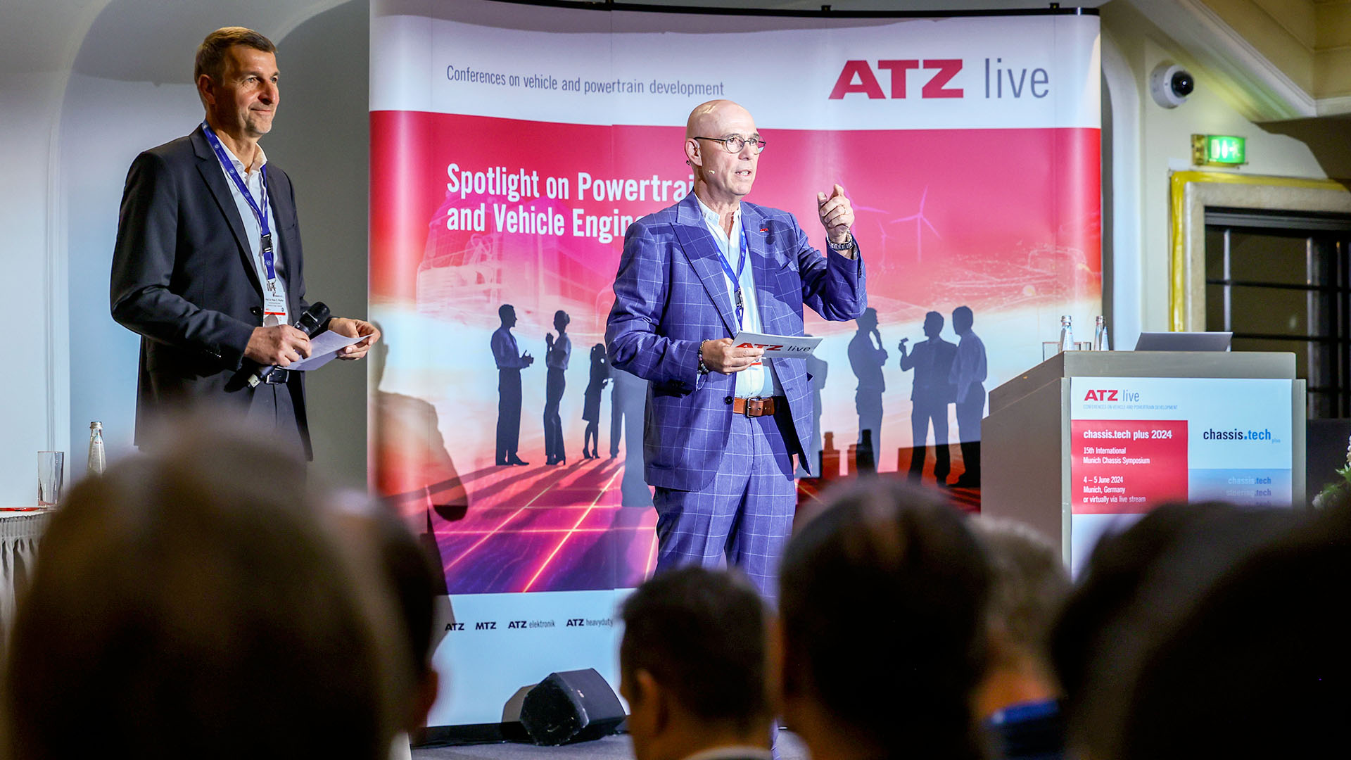 Moderatoren der Konferenz auf der Bühne. 