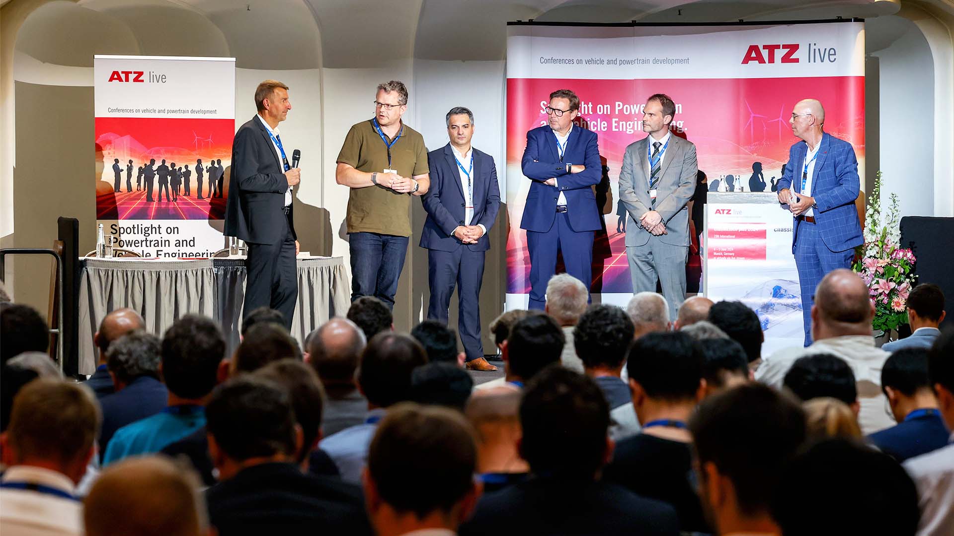 Podiumsdiskussion mit sechs Konferenzbeteiligten auf Bühne vor Publikum