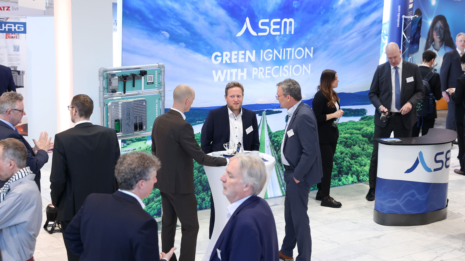 Several groups of people in the exhibition area surrounded by stands and exhibits.