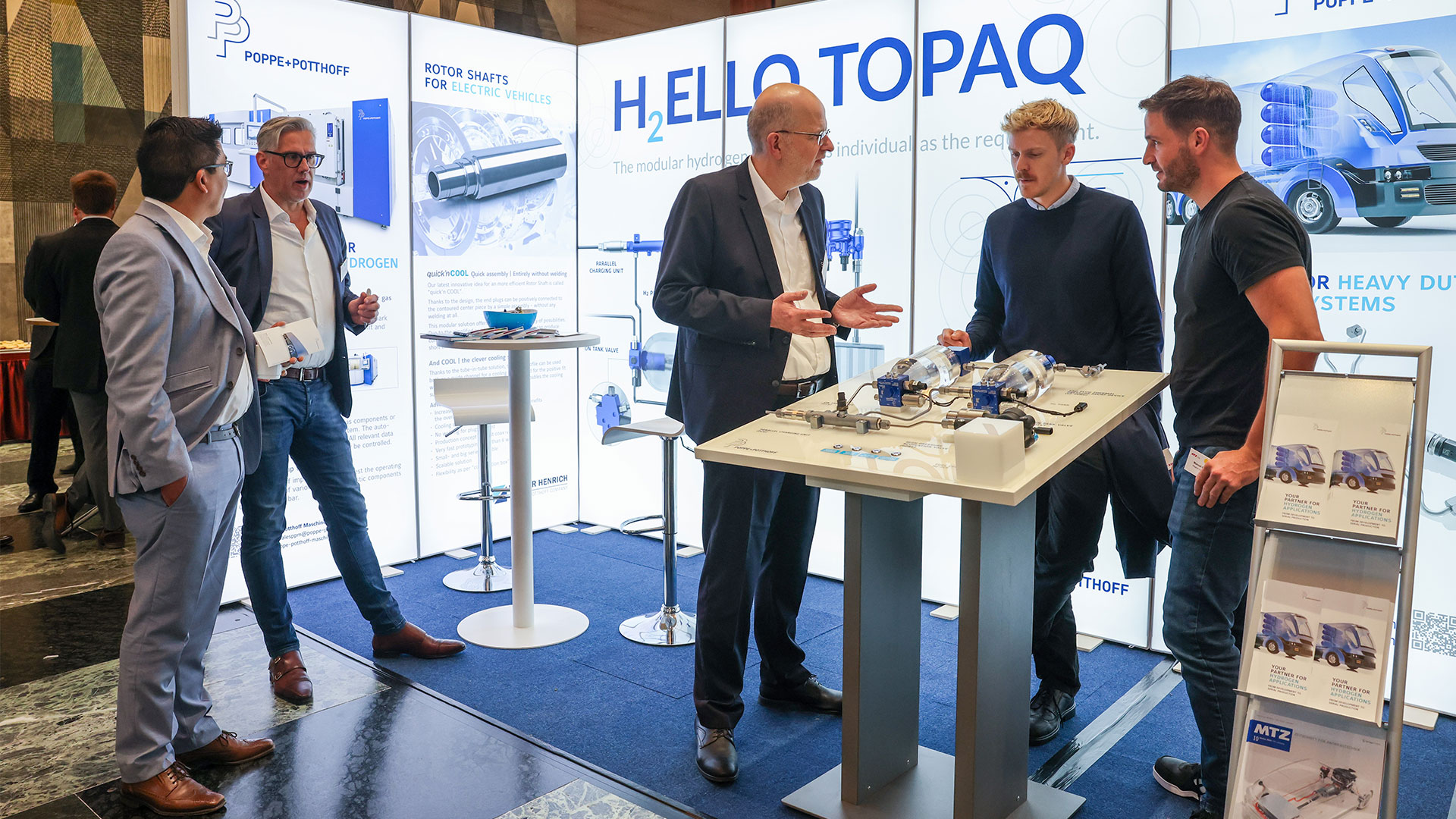 Several gentlemen in conversation at the Poppe+Potthoff exhibition stand