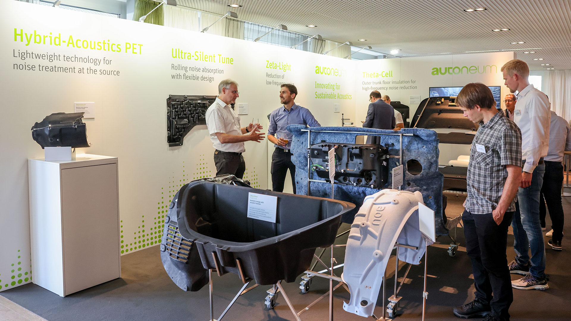 Groups of conference participants chat in the exhibition area.