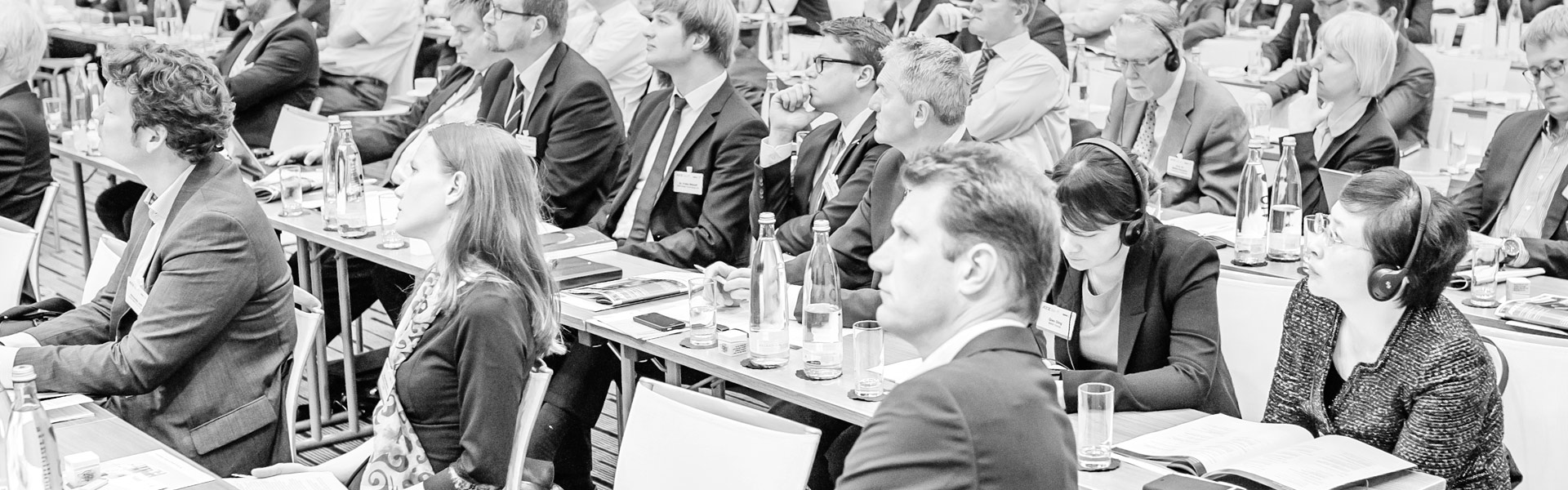 Group of conference participants seated in the plenum listening to a presentation.