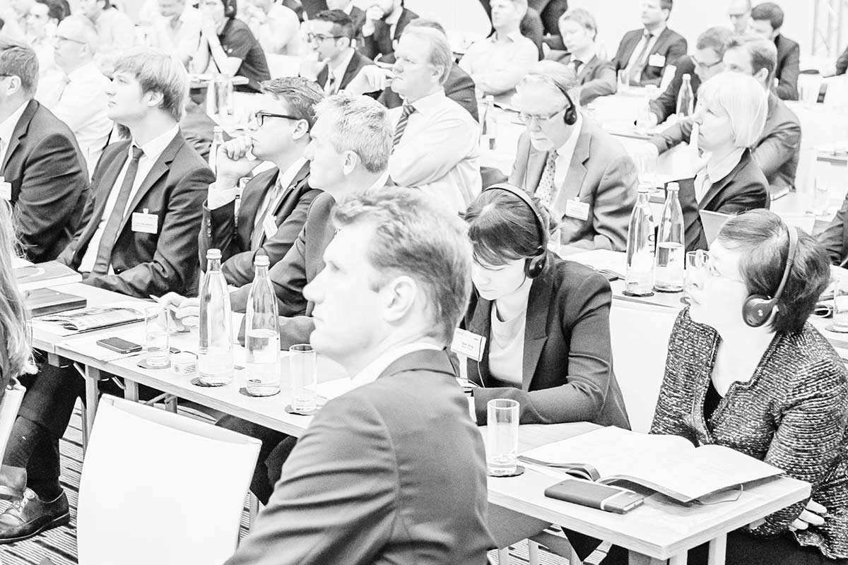 Group of conference participants seated in the plenum listening to a presentation.